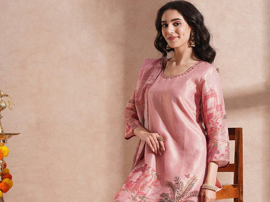 Woman wearing pink cotton kurta set with floral print, seated indoors, ethnic fashion